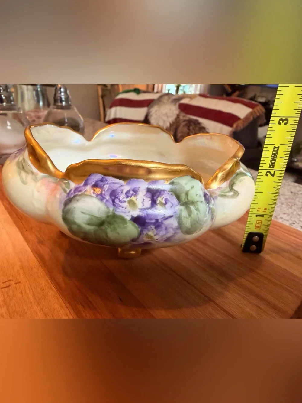 A hand-painted porcelain footed bowl with gilded rim and floral decoration.